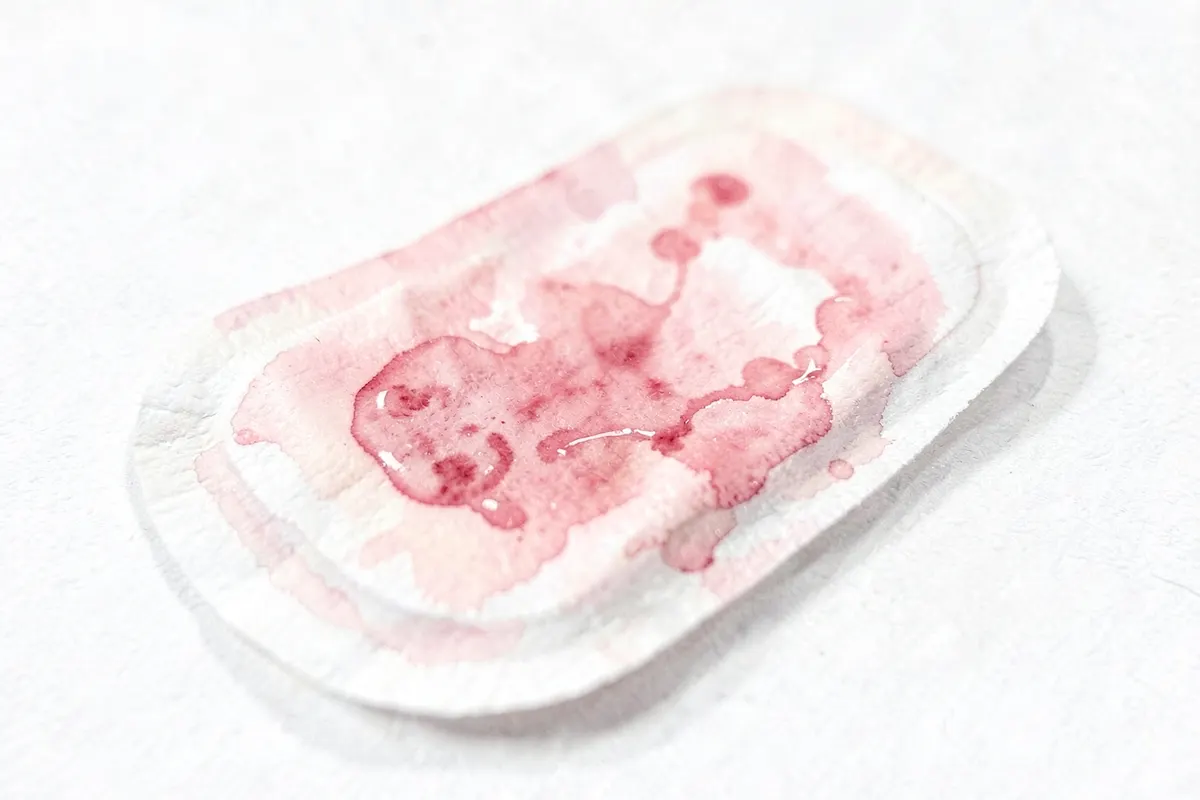 Close-up de sangue menstrual em um absorvente higiênico com um fundo desfocado