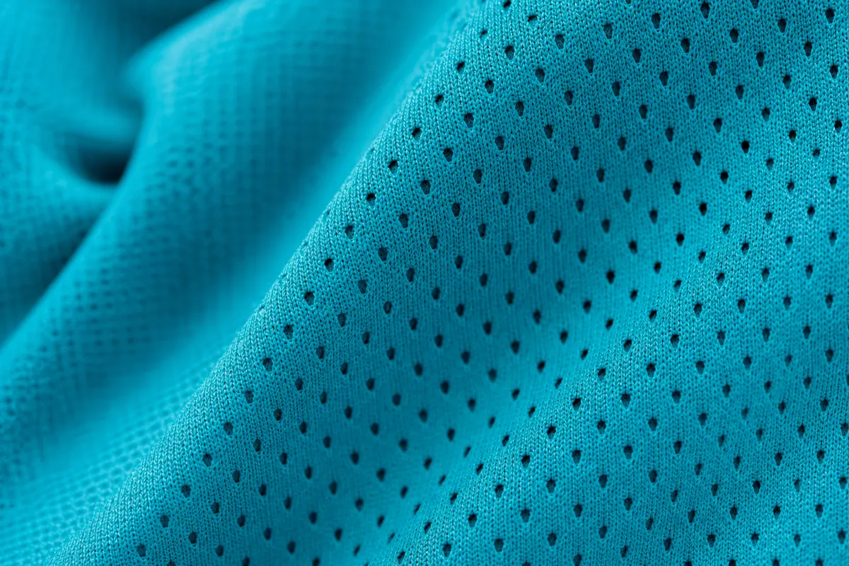 Pedaço de tecido de legging com microfuros para respirabilidade, em close-up.