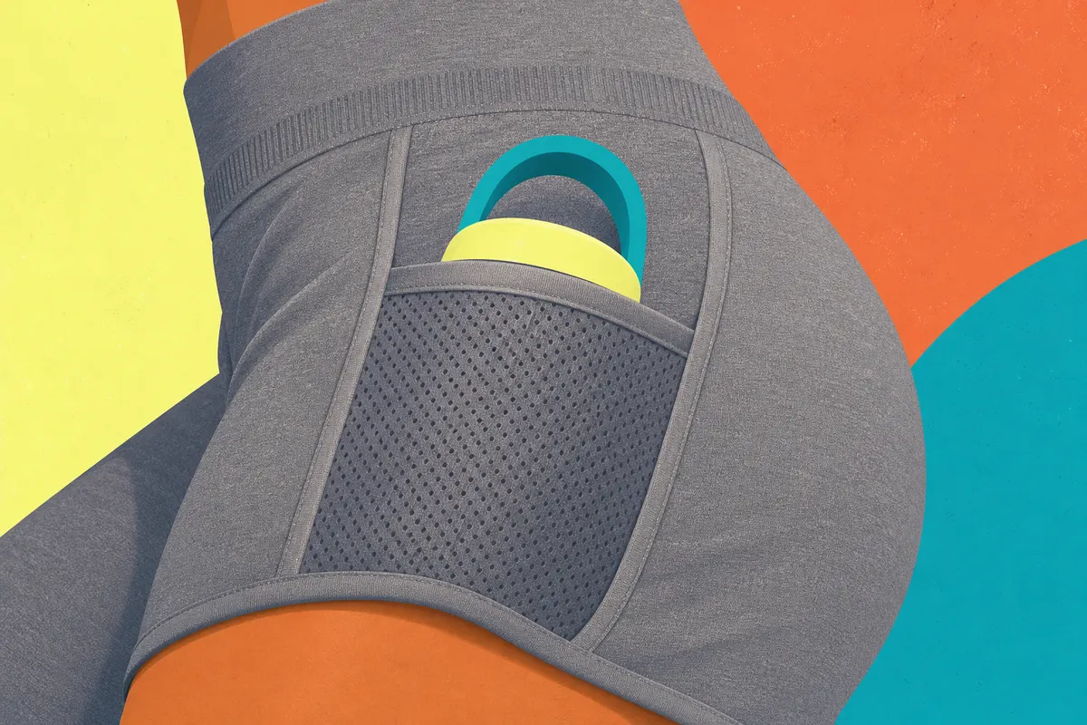 Mulher em close-up, mostrando o bolso lateral de um short fitness feminino cinza.