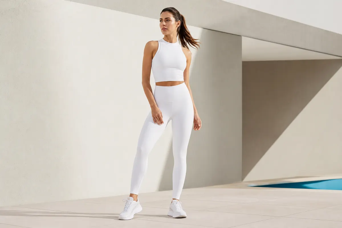 Mulher em look completo de activewear premium em frente a arquitetura moderna