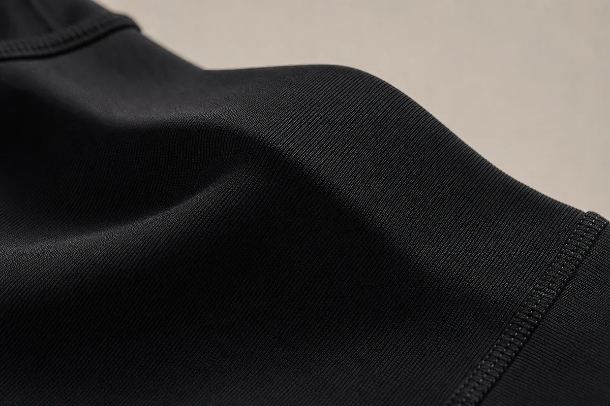 Close-up de uma legging de compressão preta com textura detalhada.