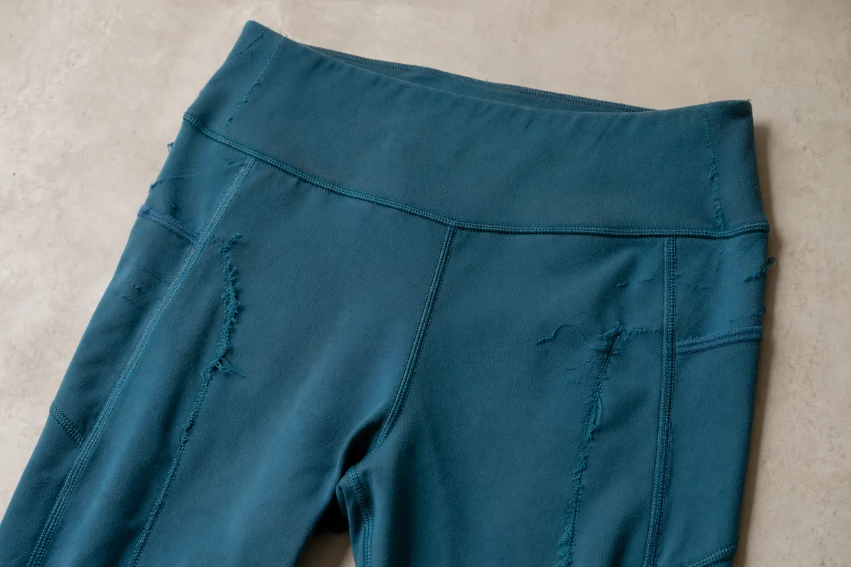 Legging de compressão desgastada com costuras soltas.