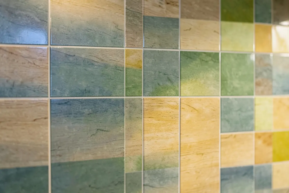 Uma parede revestida com placas de porcelanato que imitam madeira clara, com um leve brilho indicando resistência à água, em um ambiente bem iluminado.