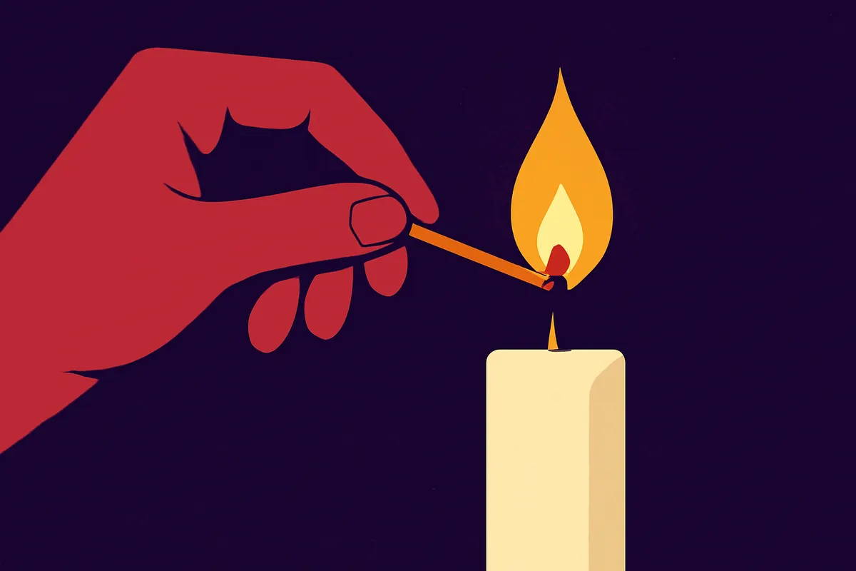 Uma pessoa acendendo uma vela com um fósforo, em um ambiente escuro