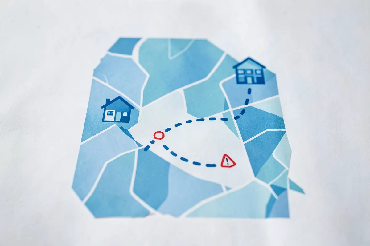 Um mapa estilizado mostrando um caminho pontilhado de uma casa para um local de trabalho, com um ícone de acidente no percurso.