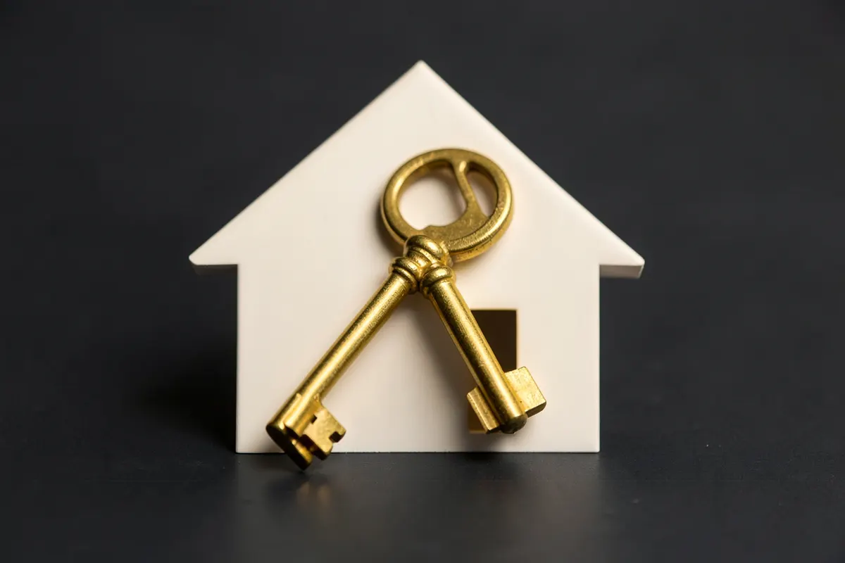 Uma casa com uma chave dourada sobreposta, simbolizando a posse e o registro de propriedade.