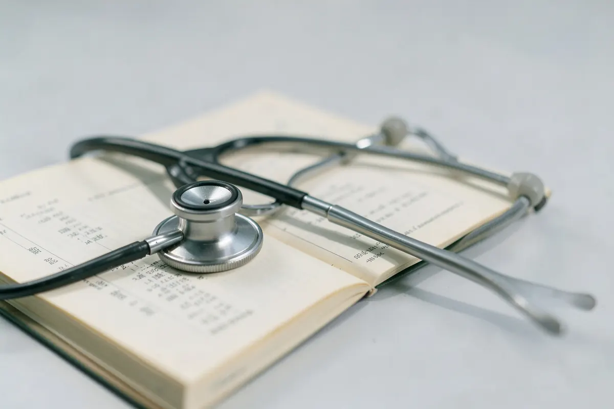 Um estetoscópio repousando sobre um prontuário médico aberto.