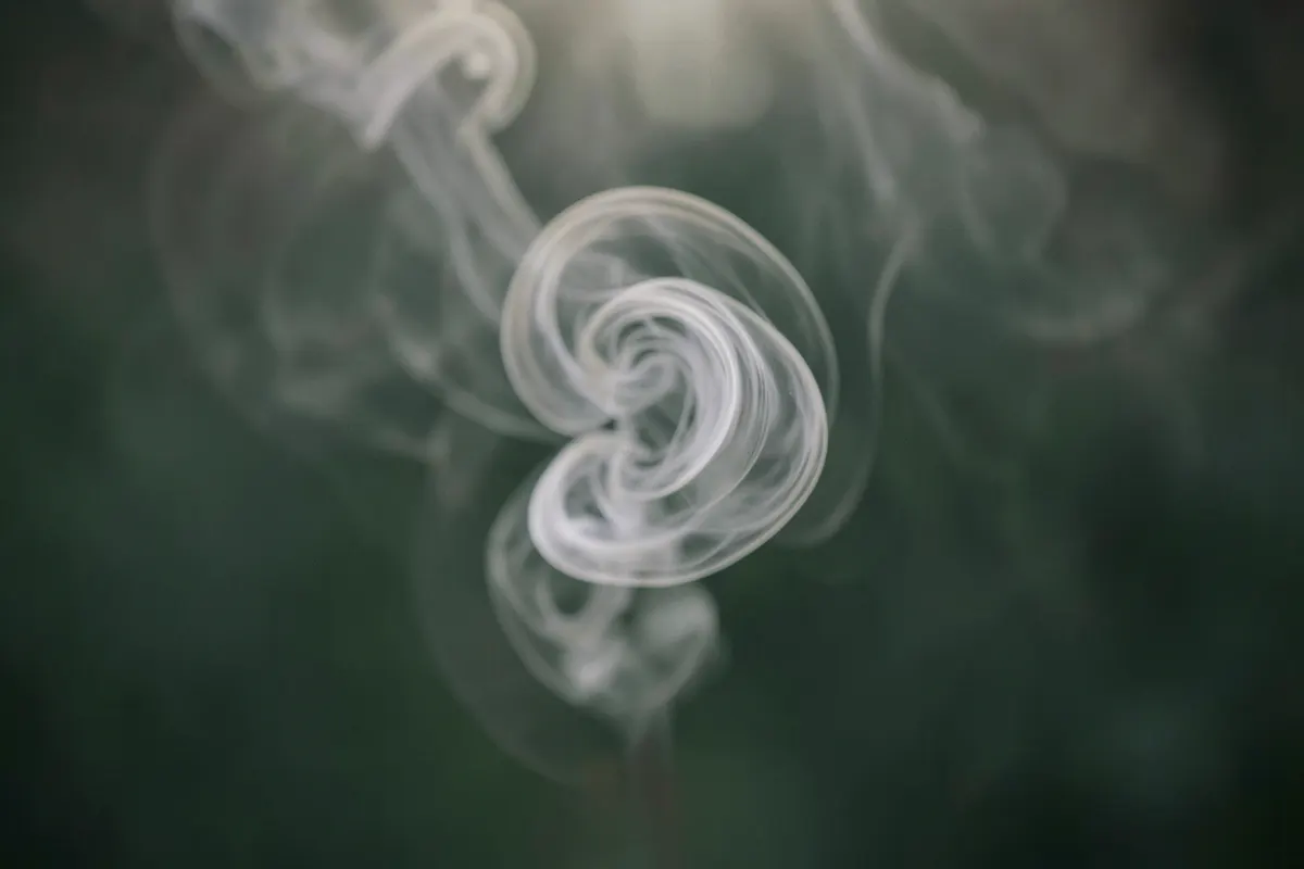 Uma espiral de fumaça cinza se dissipando lentamente, representando a natureza prolongada da ansiedade.