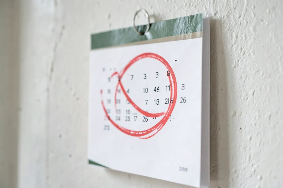 Um calendário com um dia específico circulado em vermelho, com uma expressão de preocupação.