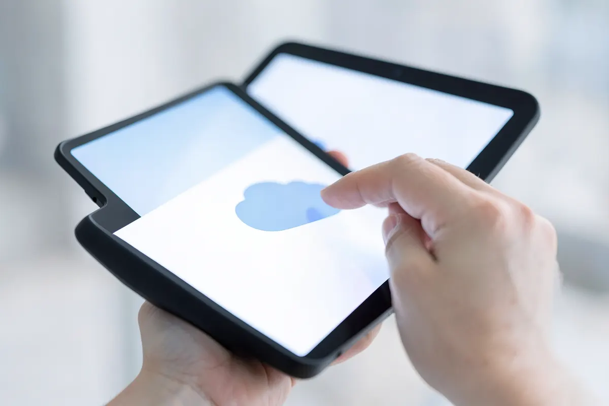 Uma pessoa seleciona um ícone de nuvem em uma tela de tablet.