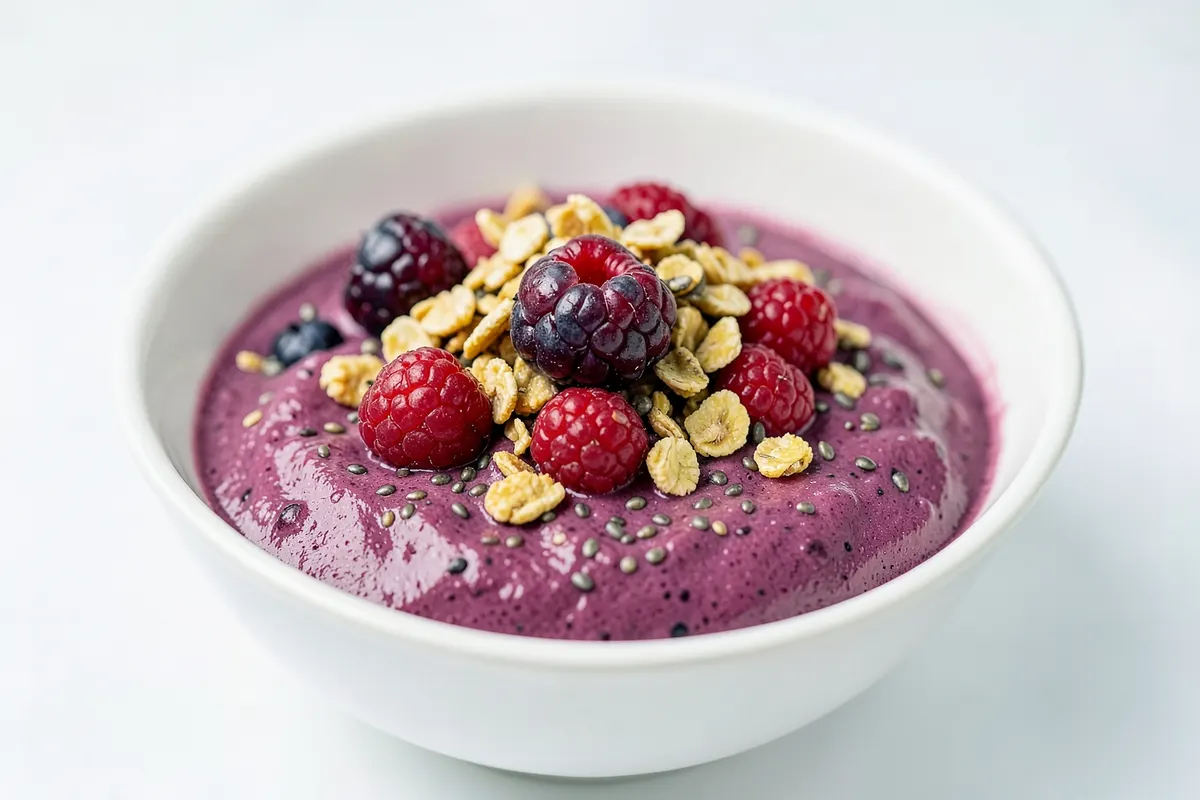 Tigela de açaí com frutas vermelhas, granola e sementes de chia.